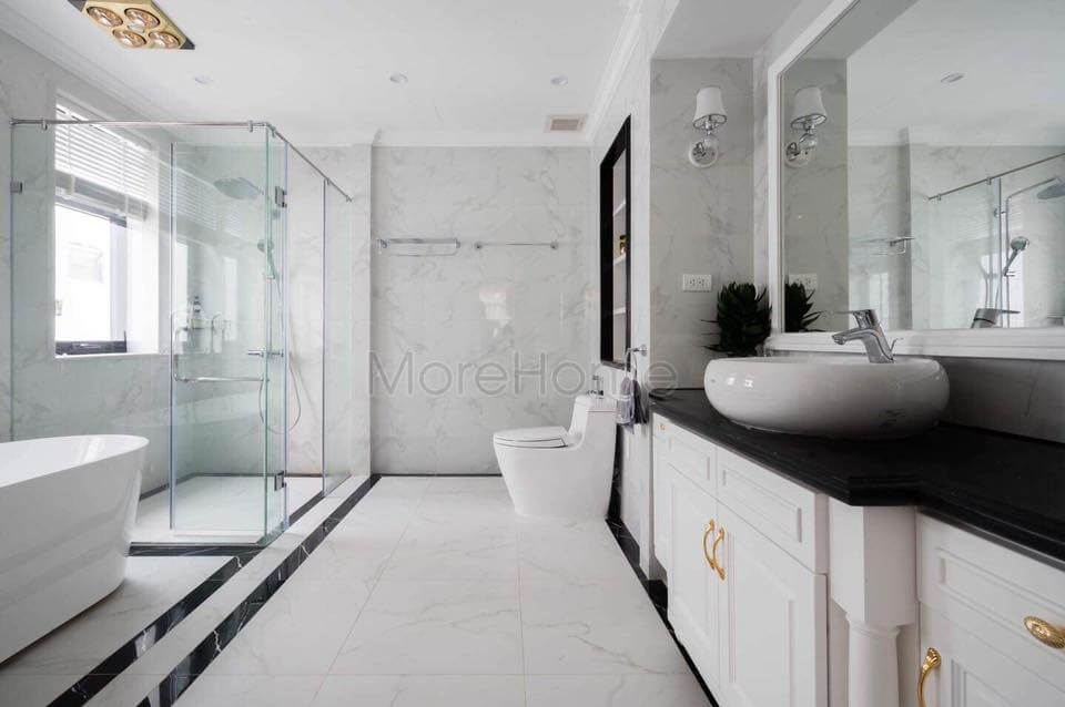 Mặt bàn lavabo màu đen làm điểm nhấn cho phòng tắm màu trắng chủ đạo đá ốp lavabo